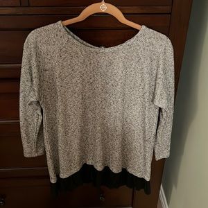 Silver tunic with black ruffle detailing at the bottom. Black ribbon insert back